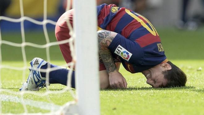 Messi on the ground in pain after the injury. 