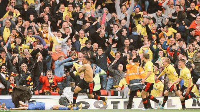 Deeney celebrates with a raucous crowd in the background. 