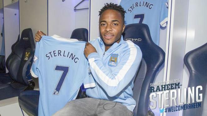 Raheem Sterling in a Man City warm up, holding his new #7 jersey. 