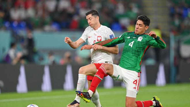 Robert Lewandowski (izquierda) y Edson Álvarez (derecha) disputan un balón.