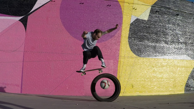 Evan jumps over a soccer ball being kicked through a tire