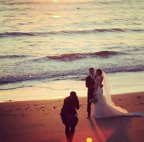 Alex Morgan and Servando Carrasco being photographed on the beach